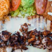 Chori Pio · Grilled chicken, topped with chorizo and cheese dip served with rice, beans and guacamole sa...