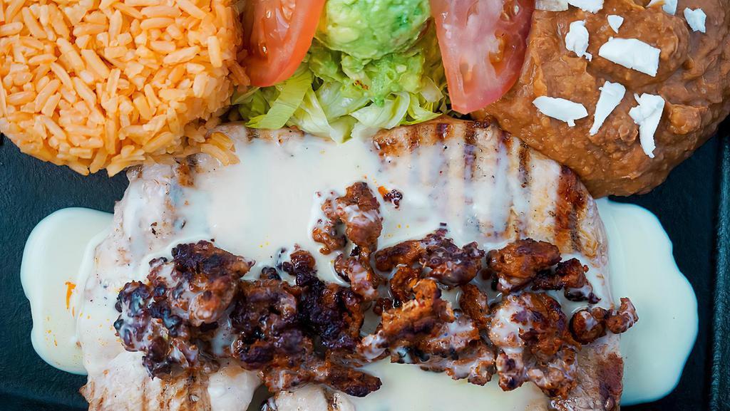 Chori Pio · Grilled chicken, topped with chorizo and cheese dip served with rice, beans and guacamole salad.