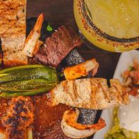 Molcajete Hacienda · Grilled chicken, sirloin steak, shrimp, chorizo, cactus, chambray onions, jalapeños, and que...