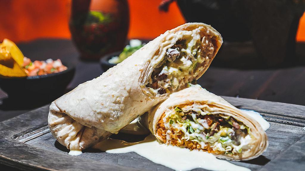 Burrito Pariente · Flour tortilla filled with your choice of steak or grilled chicken, beans rice, lettuce, sour cream,  and guacamole, topped with cheese dip.