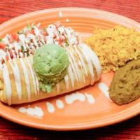 Chimichanga · Choice of ground beef or chicken rolled in a flour shell and fried. Topped with guac, lettuc...