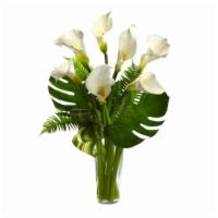 Ftd'S Always Adored Calla Lily Bouquet Vase Arrangement · White calla lilies, ferns, and monstera leaves, and lush greens arranged in a glass vase.