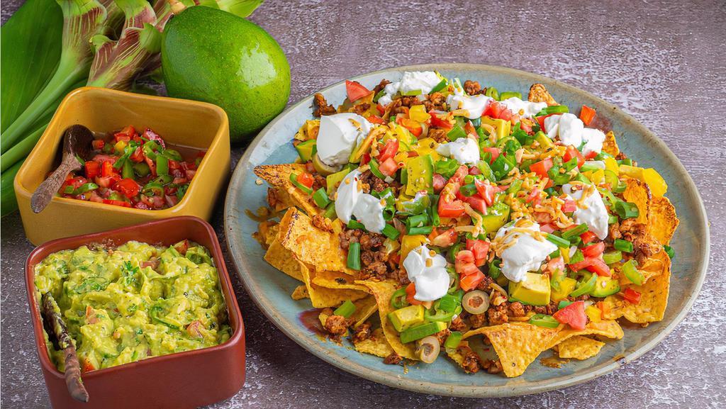 Super Nachos · Served with tomato, guacamole,jalapeños, beans, cheese, sour cream and your choice of meat or vegetarian filling.