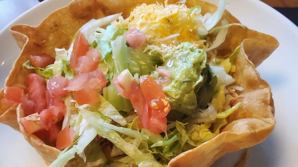 The Classic Taco Salad · A ﬂour tortilla shell with your choice of shredded beef, chicken or ground beef with lettuce, tomato, cheese guacamole, sour cream and beans.
