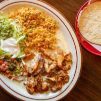 Pollo Al Queso · Grilled chicken strips, topped with melted cheese served with rice, lettuce, guacamole, sour...
