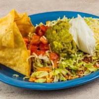 Taco Salad · Crisp shredded lettuce topped with tomatoes, cheese, sour cream, guacamole, rice, and beans ...