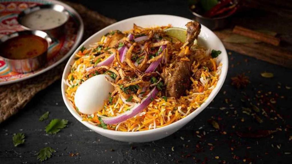 Chicken Dum Biryani · Unique traditional-layered rice dish cooked with bone-in chicken, Basmati rice, and exotic spices in true Nawabi style