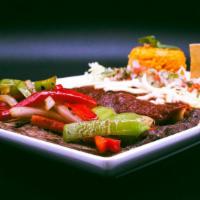 Tampiquena · A dinner served with grilled skirt steak, peppers, enchilada a small quesadilla and rice and...