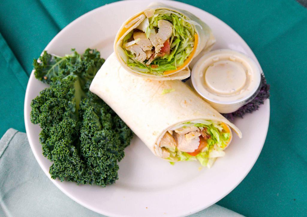 Chicken Ranchero Wrap · Grilled marinated chicken breast, melted cheddar cheese, romaine lettuce, juicy tomatoes, crispy smoked bacon and a side of homemade ranch.