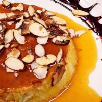 Flan · Traditional soft custard with roasted nuts and chocolate sauce.