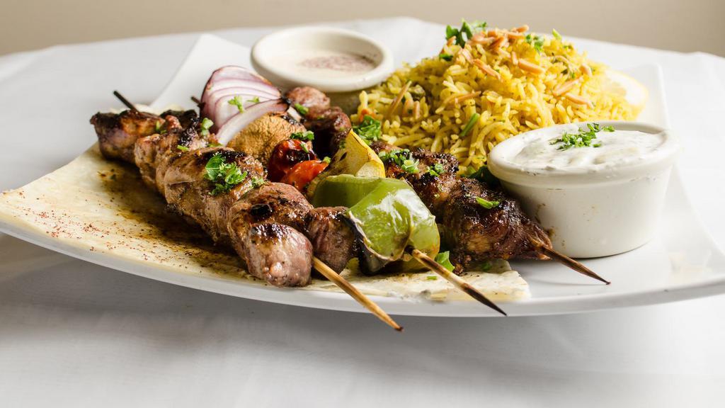 Lamb Kebab Platter · Marinated lamb, two  square of grilled lamb kebobs with tomatoes, green pepper and onion. Served over a bed of basmati rice, comes with small greek salad.
