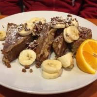 Banana Bread French Toast · Fresh baked banana bread topped with more bananas and roasted pecans