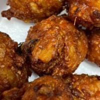 Vegetable Pakora (7) · Sliced onions, potatoes mixed with chickpeas flour, fried until golden brown.