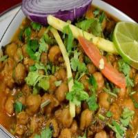 Chana Masala · Zesty garbanzo bean curry with sautéed onions, tomatoes, garlic and ginger, garnished with c...