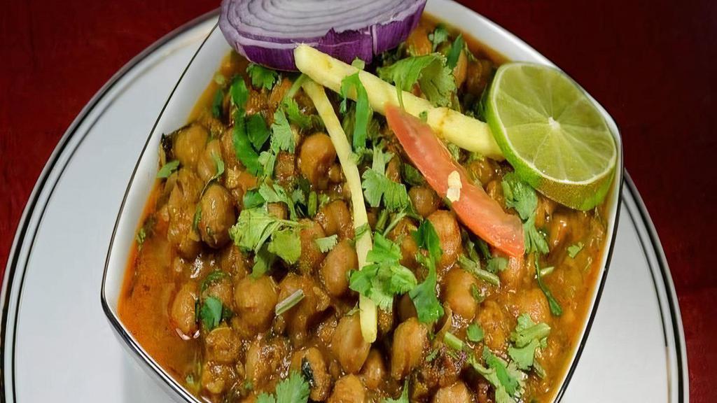 Chana Masala · Zesty garbanzo bean curry with sautéed onions, tomatoes, garlic and ginger, garnished with cilantro.