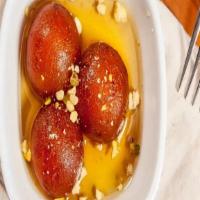 Gulab Jamun · A traditional milk based pastry balls served warm in a honey flavored syrup.