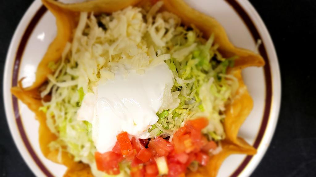 Taco Salad · Crispy flour shell served with your choice of ground beef or chicken with lettuce, tomatoes, cheese and sour cream.
