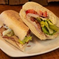 Ric’S Club · Black forest ham smoked turkey, applewood smoked bacon and Swiss cheese with lettuce, tomato...