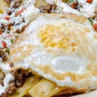 Chilaquiles Verdes Meat · Crispy corn tortillas, smothered in a verde sauce and two Over easy egg. Meat, cilantro, que...