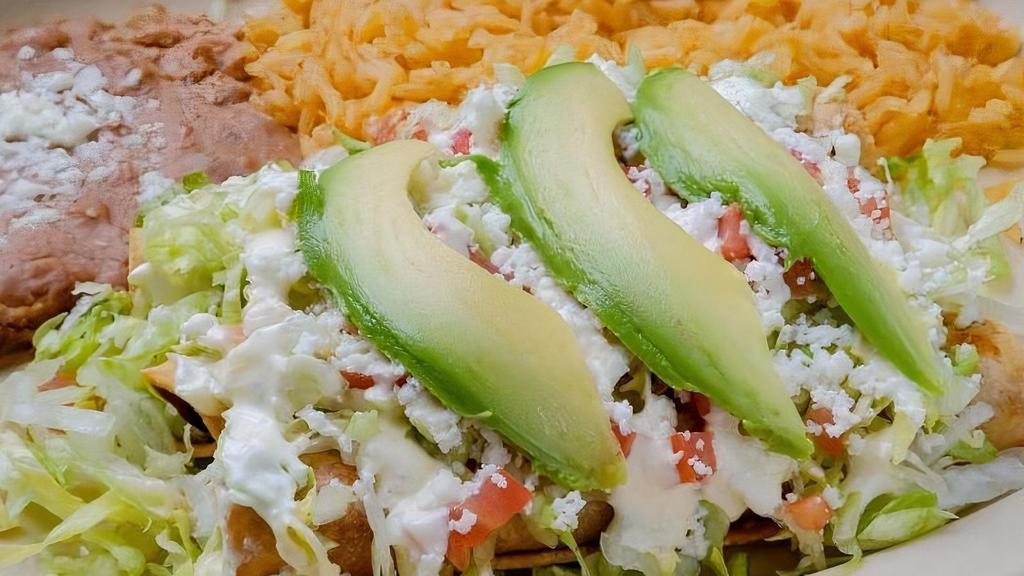 Platillo Flautas · Rolled up fried corn tortillas stuffed with chicken or shredded beef. topped with lettuce, sour cream tomato & avocado served with rice and beans.