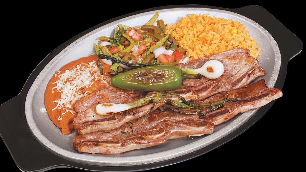 Costilla De Res · Grilled short ribs served with cactus, grilled onions, and peppers. Served with rice and beans.