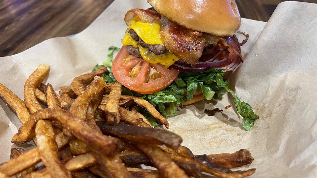 The Dude Deluxe · Two 3-ounce patties smashed and flash grilled, and topped with apple-wood bacon, American cheese, lettuce, tomato and onion.