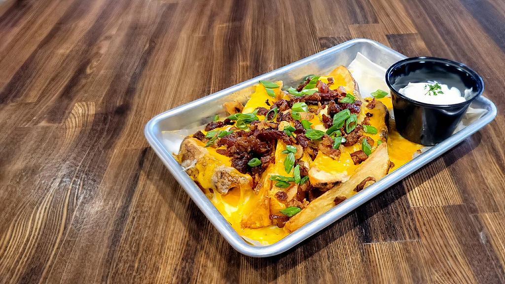 Loaded Potato Wedges · Sliced potato wedges topped with melted Colby-Jack cheese, bacon bits and green onion. Sour cream on the side.