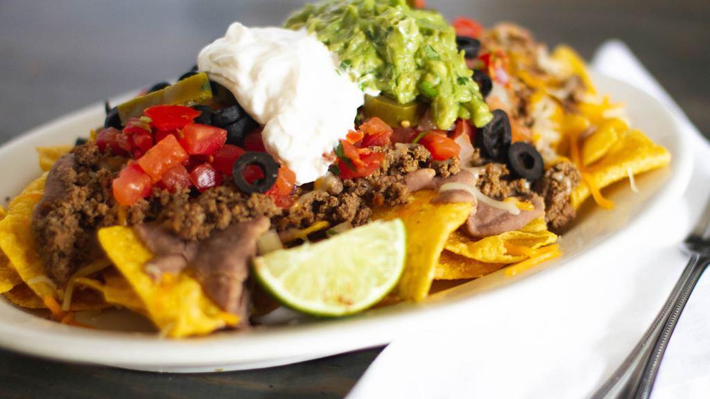 Nachos With Meat · Corn chips covered with your choice of meat, cheese, sauce, beans, lettuce, jalapenos, guacamole, pico de gallo, and sour cream.