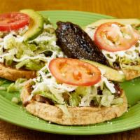 Sopes · Frijoles, lechuga, queso, crema y cebolla / Beans, lettuce, cheese, cream, and onion.