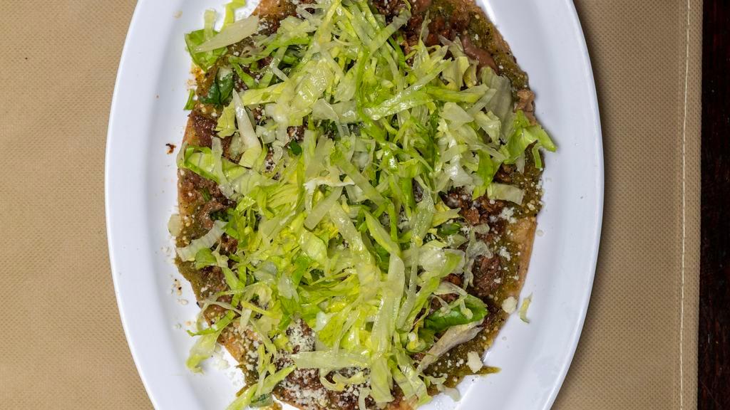Huaraches · Oval shaped tortilla filled with refried beans and topped with green hot salsa, lettuce, cotija cheese, onion, and cilantro. Includes rice, beans, and tortilla.