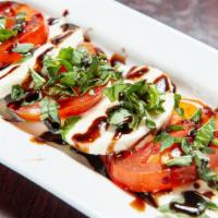 Caprese Salad · Layers of basil, mozzarella, and tomato drizzled with a balsamic reduction.