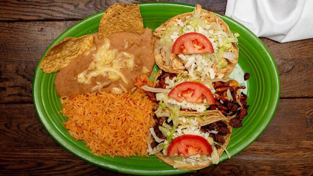 Taco Dinner · Three tacos with your choice of ground beef, chicken, pork (al pastor), shredded beef (desebrada), or chopped steak. Topped with lettuce, tomato and cheese. Served with a side of Spanish rice and refried beans.