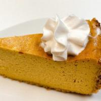 Pumpkin Cheesecake · Homemade pumpkin cheesecake with rich texture, topped with whip cream.