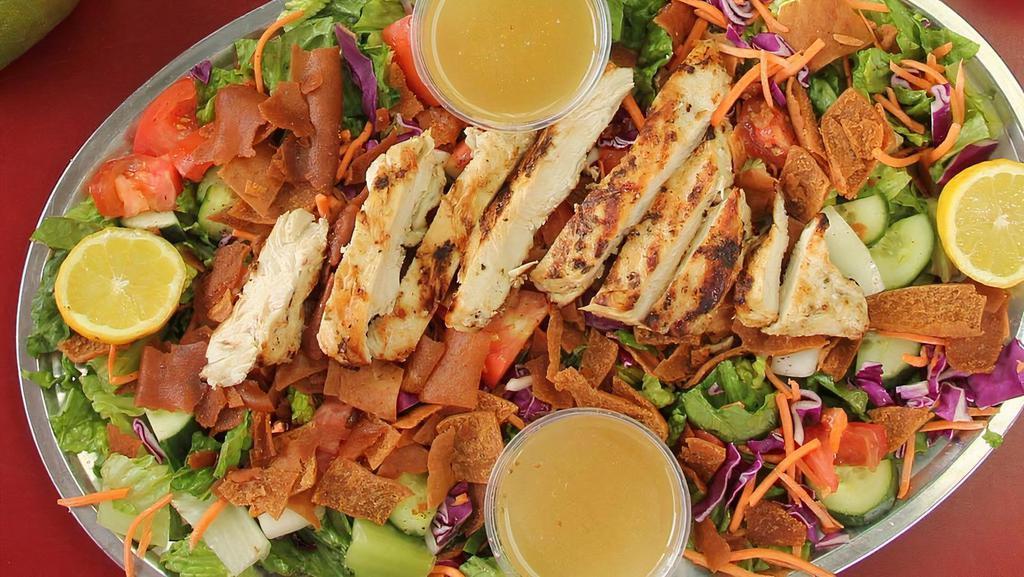 Large Fattoush Tawook · Juicy grilled chicken with garden salad topped with crunchy toasted pita bread, and Boostan seasoning along with house dressing on the side.