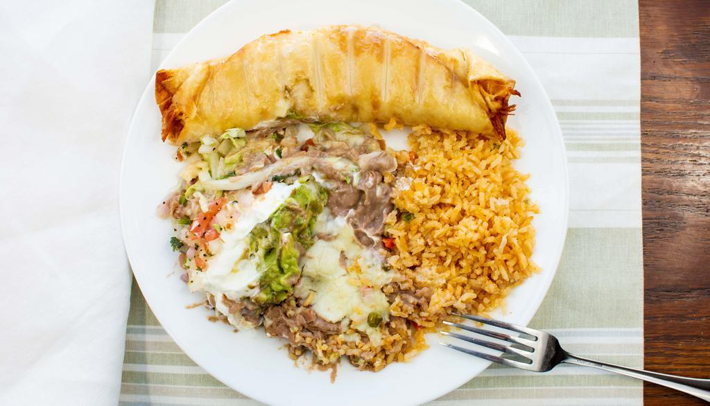 Chimichanga · A flour tortilla loaded with ground beef or shredded chicken, deep fried to golden brown and topped with cheese sauce. Served with rice, beans, lettuce, pico de gallo, guacamole and sour cream.