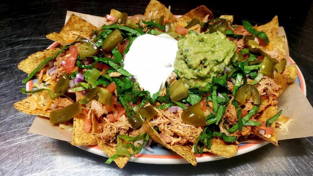 Super Nachos · Tortilla chips with beans, cheese, lettuce, tomato, sour cream, onion, guacamole and pickled jalapeños.