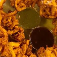 Pakoras · VEGAN - Sliced onions and cilantro mixed in a batter then fried into crispy puffs. All toppe...