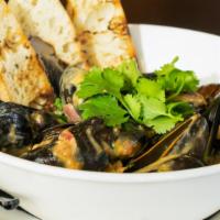 Steamed Mussels · Red curry, coconut milk, Thai basil, lime, and white wine. Served with grilled baguette.