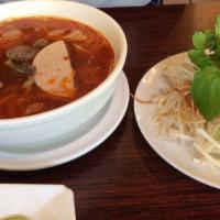 Bun Bo Hue · Hot and spicy hue traditional rice noodle soup with beef and pork cake, onion, cilantro. Spi...
