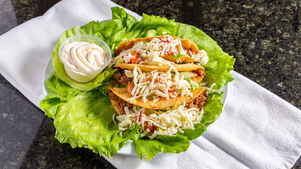 Tacos De Carne Molida · Three ground beef tacos with lettuce, chopped tomato, sour cream, and grated Monterrey cheese served on a bed of romaine lettuce.