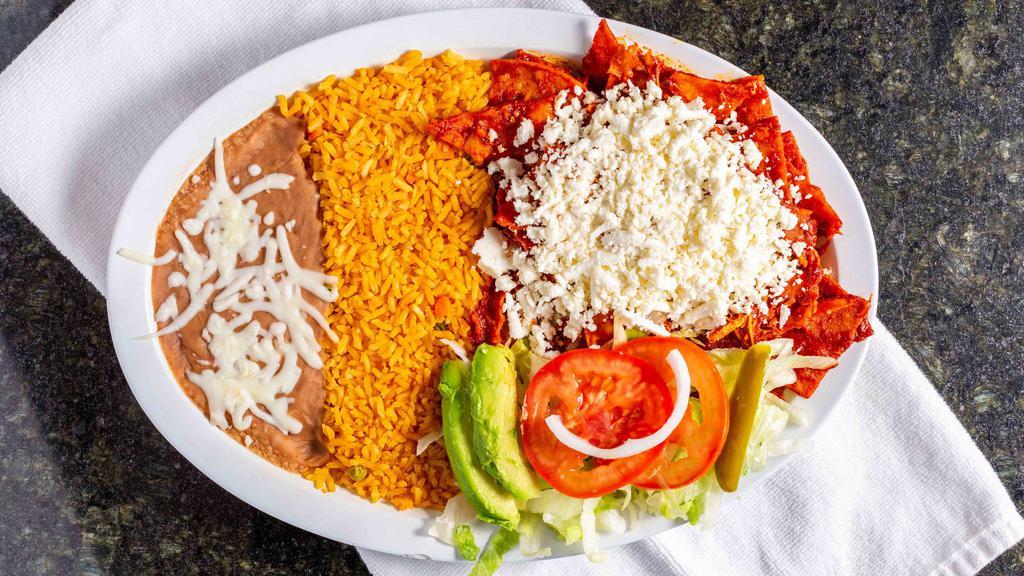 Chilaquiles · Homemade corn chip tortillas covered with green or red sauce and mozzarella cheese, topped with sour cream and queso fresco. Served with lettuce, tomatoes, onions, jalapeños, avocado, rice and refried beans.