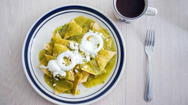 Chilaquiles · Cut stir-fried corn tortillas simmered in green or ranchero sauce topped with queso fresco, sour cream, onion and served with your choice of protein.