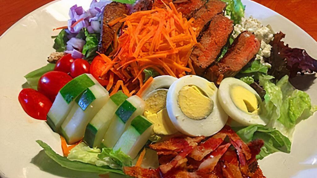 Steak Salad · Seared flat iron, mixed greens, blue cheese, grape tomatoes, red onion, cucumber, hard boiled eggs, and crispy bacon served with house made Chimichurri dressing.