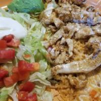 Chori Pollo · Grilled chicken breast with chorizo, topped with cheese sauce, served with rice and beans.