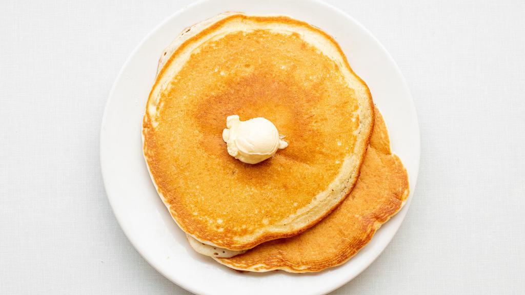 Pancakes · Three buttermilk pancakes topped with whipped butter and warm maple syrup.