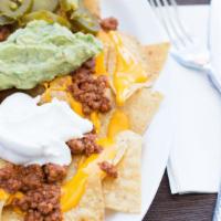 Super Nachos · Tortilla chips topped with your choice of meat, cheddar cheese, tomato, guacamole, sour crea...