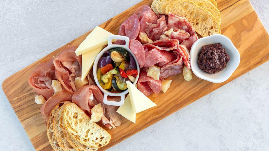 Italian Charcuterie Tray · The perfect antipasto for sharing! A mix of thin slices of prosciutto, Genoa & Milano salamis, fontina and parmesan cheeses accompanied with olive oil, oven-roasted vegetables and Kalamata olives tapenade. Served with ciabatta crostinis.