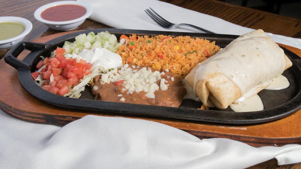 Chimichanga  · Big flour tortilla filled with your choice of meat, beans and cheese. Topped with cheese sauce. Served with lettuce, tomatoes, sour cream and cheese