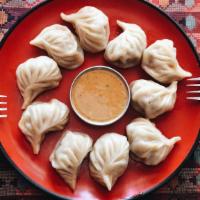 Chicken Momo · Hand wrapped steamed dumplings made with a mildly spiced chicken filling.