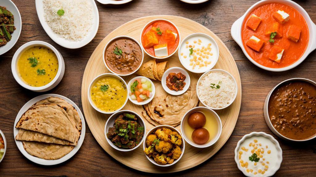 Chicken Thali · Traditional Nepali platter featuring a combination of a fresh vegetable curry, chicken curry, lentil soup, and aromatic Basmati rice.